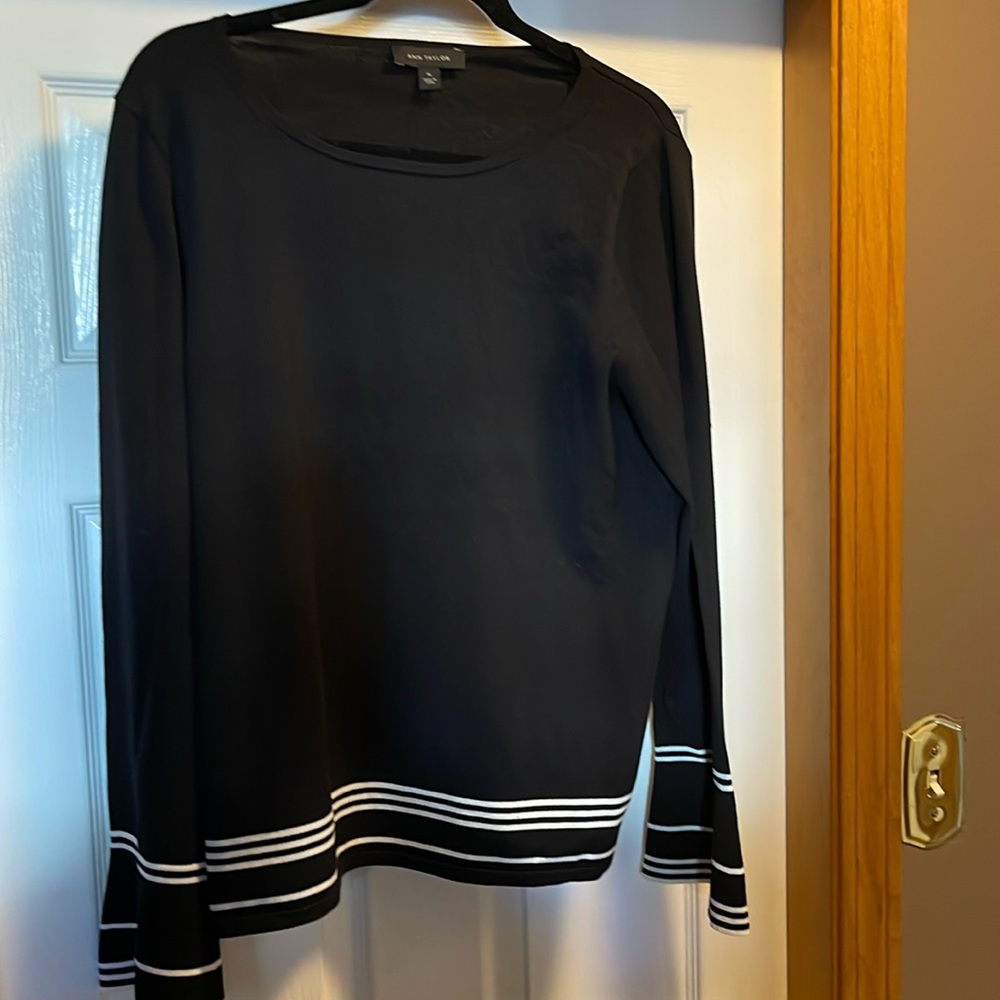 AT XL black long sleeve sweater with white stripes on sleeves and at bottom.